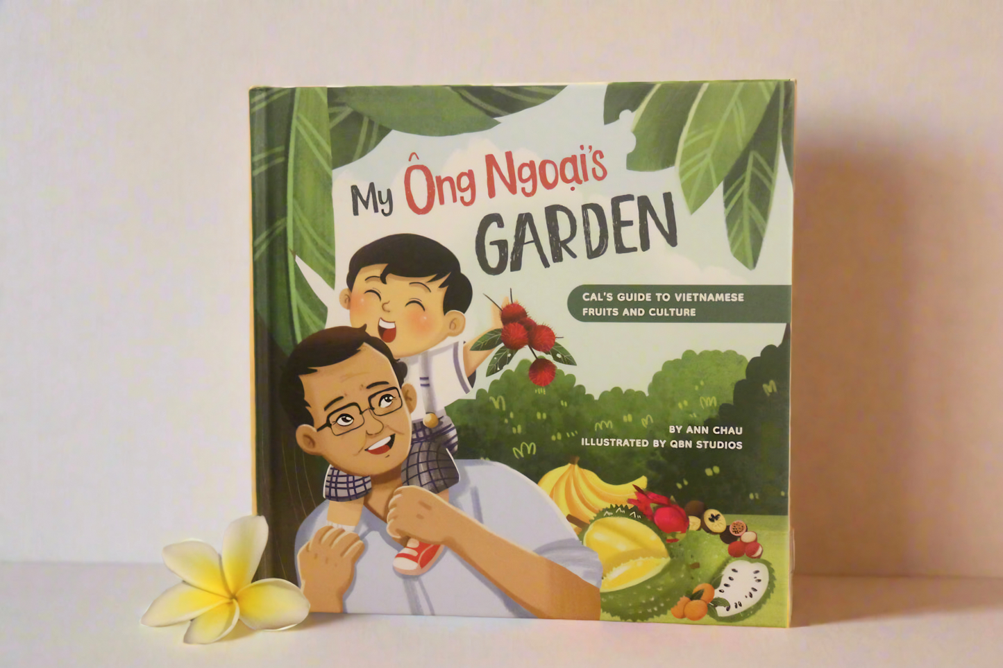 Children's book titled 'My Ông Ngoai's Garden' on a white surface with a flower.